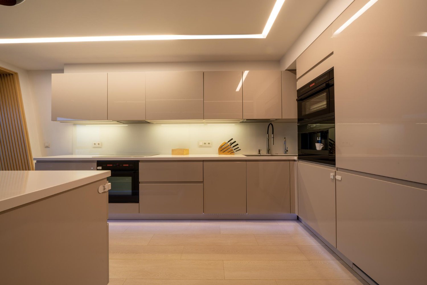 Cozinha planejada de alto padrão, iluminada, representando o sonho de um projeto bem executado.