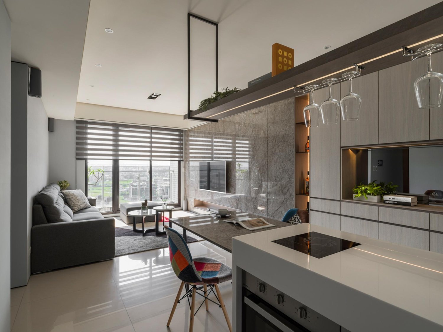 Ilha de cozinha planejada com banquetas, servindo como elemento de transição para a sala.