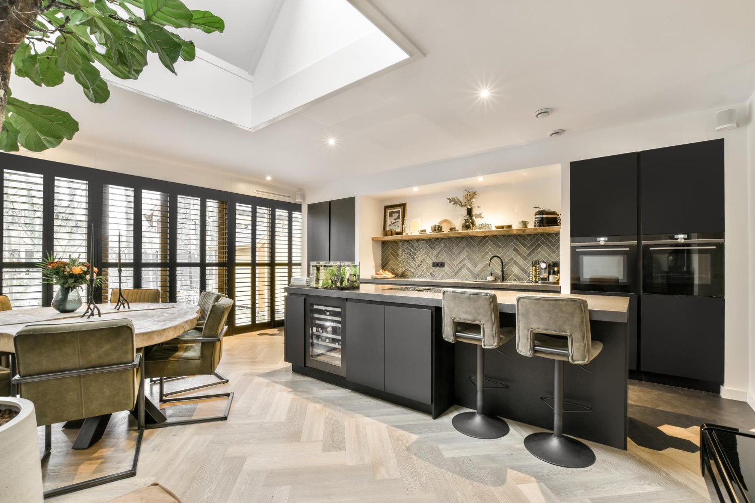 Cozinha planejada que utiliza madeira ripada para se conectar visualmente com a sala de estar.