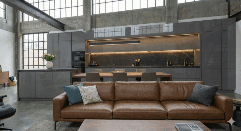 Cozinha planejada para apartamento pequeno estilo loft, com armários em laca cinza e bancada em Dekton, exemplificando o luxo compacto