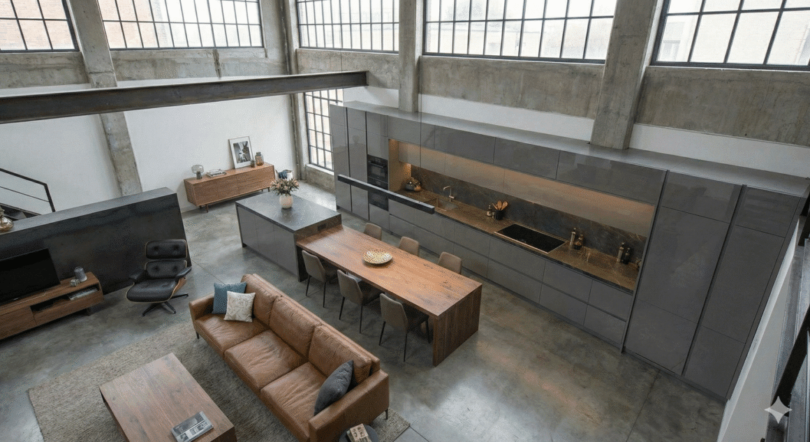Cozinha planejada para apartamento pequeno estilo loft, com armários em laca cinza e bancada em Dekton, exemplificando o luxo compacto.