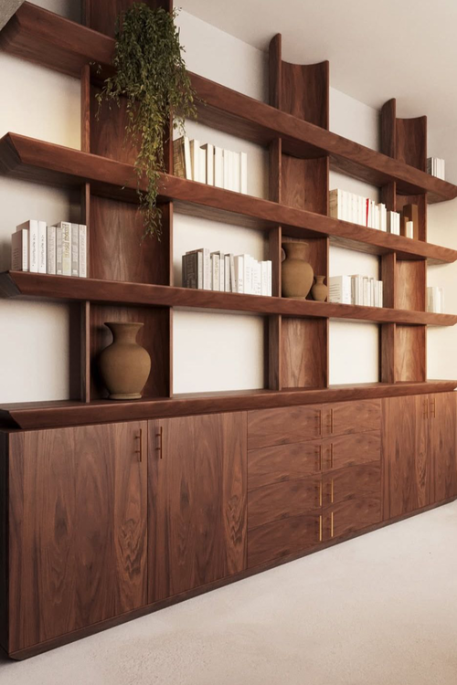 Estante de madeira escura ocupando toda a parede, do piso ao teto, com nichos iluminados por fitas de LED verticais e escada metálica de correr.