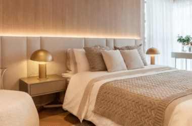 Banheiro de casal com cuba dupla de apoio branca, bancada de mármore e espelhos redondos com iluminação LED retroiluminada. Exemplo de banheiro suíte master luxo da ProjeFácil.