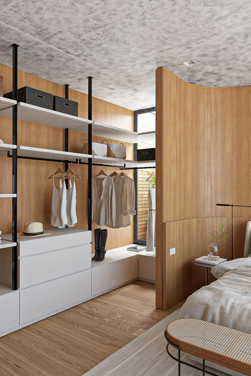 Closet aberto planejado em madeira escura com nichos iluminados por fitas de LED verticais e roupas organizadas por cores. Exemplo de vantagens closet aberto.