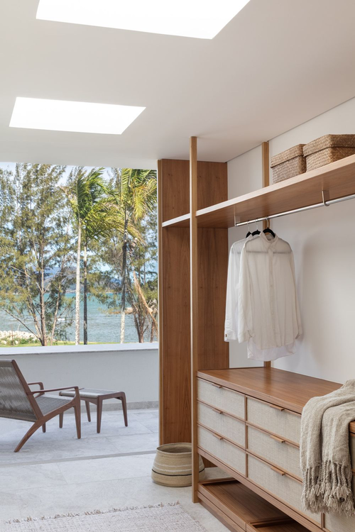 Closet fechado com portas lisas, trazendo minimalismo e escondendo roupas, gerando sensação de ordem no quarto.