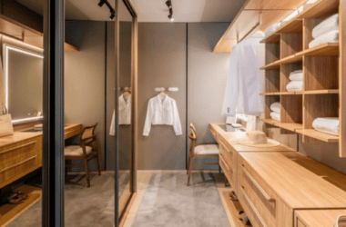 Quarto de casal com closet fechado por portas de laca cinza sem puxadores aparentes (fecho-toque). Estética de closet planejado com portas.
