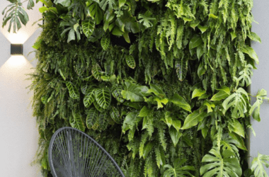 Detalhe de folhagens de jiboia e samambaia em jardim vertical interno. Seleção de plantas que amam sombra para apartamentos.