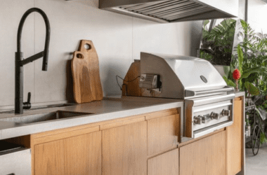 Churrasqueira de alto padrão revestida em porcelanato que imita aço corten, com iluminação interna e acabamento em inox.
